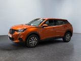 un SUV orange garé dans une pièce aux murs blancs