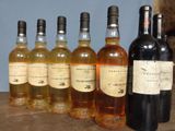 several bottles of wine are lined up on a wooden table