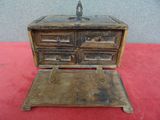 a small wooden box with drawers on a red surface