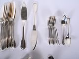 a lot of spoons and forks laid out on the table