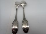 two spoons and a fork sitting on a table
