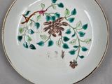 a white plate with green leaves and flowers on it
