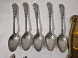 six silver spoons are lined up next to a mirror