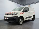 une camionnette Citroën rayée de rouge et de blanc, garée dans un garage