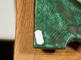 a close up of a green clock on a wooden table