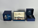 three watches in a blue box and a watch in a blue box