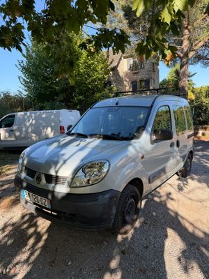 La camionnette est garée sur le bord de la route, près des arbres.