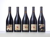 four bottles of wine are lined up on a table