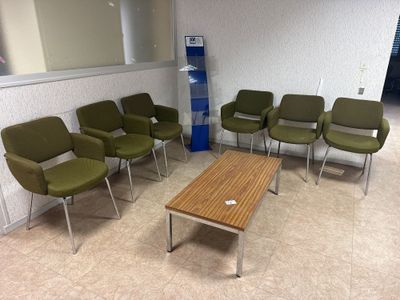 des chaises et une table dans une salle d'attente, avec une fontaine à eau en arrière-plan