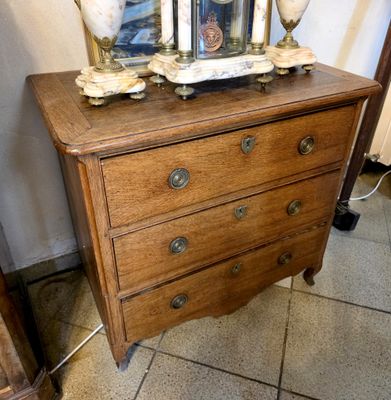 a small chest of drawers with a clock on top