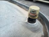 a bottle of beer sitting on top of a metal container