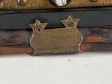 an antique wooden box with a brass plate on top of it