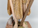 an old statue of a woman holding a cross and a sword