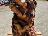a wooden sculpture of horses on a pallet in a parking lot