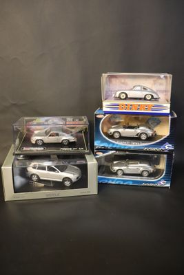 three toy cars are sitting in boxes on a black surface