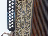 an old black and gold accordion sitting on top of a wooden table