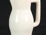 un vase blanc avec un couvercle jaune sur fond noir