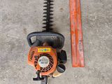 a close up of a chainsaw and a ruler on a concrete floor