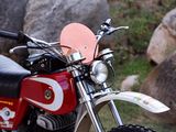 a red and white motorcycle parked in front of some rocks