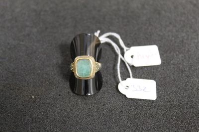 une bague sertie d'une pierre verte et munie d'une étiquette de prix