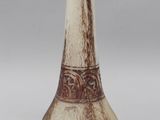 a white and brown vase sitting on a table