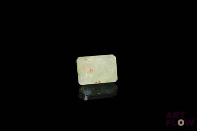 an image of a piece of green jade on a black surface