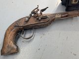 a gun that is on a table next to a suitcase
