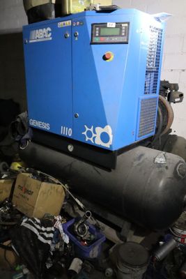 un compresseur d'air bleu posé sur un tas d'objets divers
