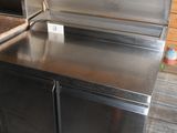 un plan de travail en inox avec un évier au milieu