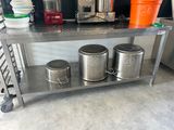 three buckets sitting on a metal shelf in a kitchen