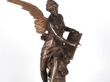 an antique bronze statue of an angel holding a book