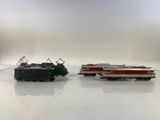two toy trains sitting side by side on a white surface