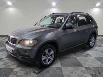 a picture of a silver bmw suv parked in a garage