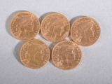 four gold coins sitting on top of each other on a white surface