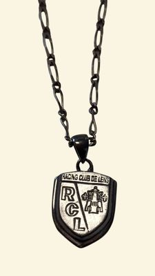 a close up of a necklace on a chain with a badge on it
