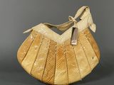 an image of a beige purse with a bow on the handle