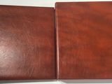 two brown leather folders sitting on top of a white table