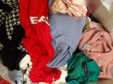 a pile of clothes sitting on a couch in a living room