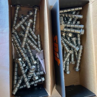 deux boîtes de vis dans une boîte posée sur une table