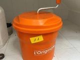 un seau orange muni d'une poignée, posé sur un comptoir