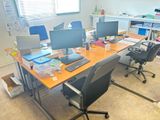 une image représentant un bureau avec deux ordinateurs de bureau et un ordinateur portable