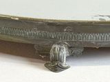 a silver plate on a white table with a silver handle