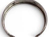 a close up of a metal bracelet on a white surface