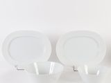 three white plates and two bowls on the table