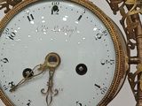 a gold clock with a chain around it on a table