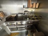 a kitchen with a stove, sink, and oven in it