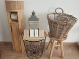 a wicker basket on a stool next to a basket with a lantern