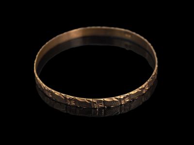 gros plan d'une bague en or sur fond noir