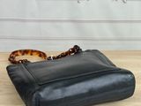 a black leather purse sitting on top of a wooden table