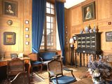 un salon avec beaucoup de meubles et de tableaux aux murs